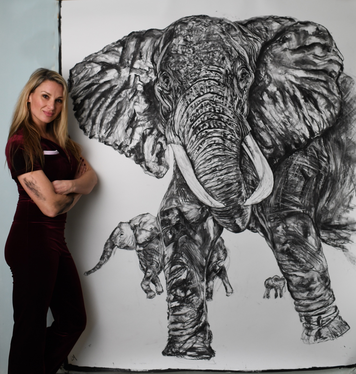 Lucy standing beside her large elephant artwork